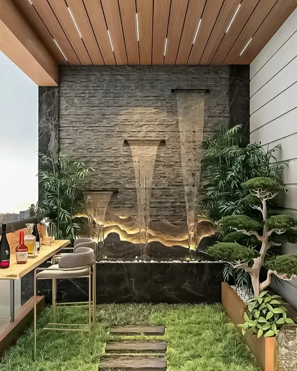 A luxurious balcony featuring a custom bar, a tranquil water feature, and lush greenery. This design creates a perfect setting for entertaining guests or enjoying a quiet evening drink.
