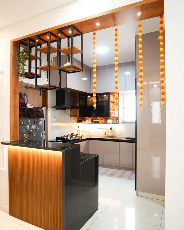 This open-concept kitchen with an integrated breakfast bar is the heart of the home, designed for both everyday living and entertaining. We used a combination of warm wood tones and sleek laminates, highlighted by under-counter and hanging pendant lights to create an inviting, modern space.