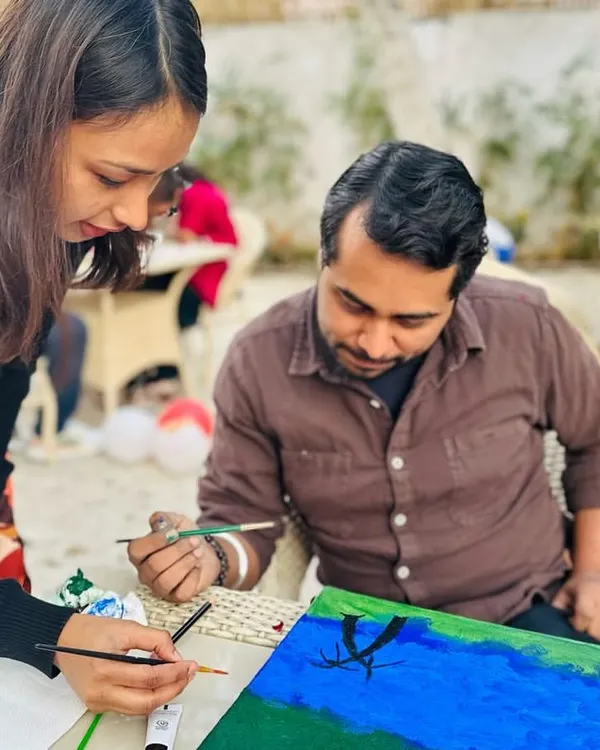 This is what it's all about for me: guiding you through the creative process. Here, I'm helping a participant with their brushwork during a relaxed outdoor painting session. It's not about perfection, but about finding your flow and enjoying the moment.