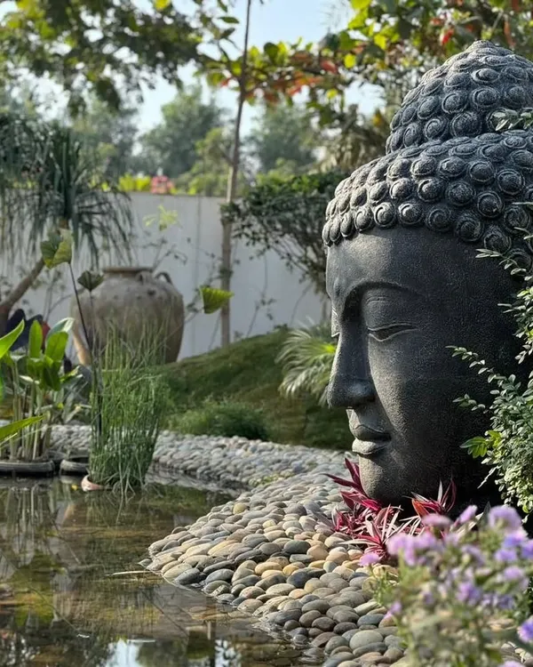 This is how we imagine our statues living in the world. Our large 'Lama Buddha' head, crafted from dark lavastone, creates a breathtaking focal point in this tranquil garden pond designed by a client.