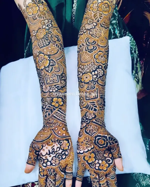 A complete view of the intricate bridal mehndi for Raazia. The design is packed with details, including floral patterns, geometric checks, and the bride's name beautifully written on the palm.