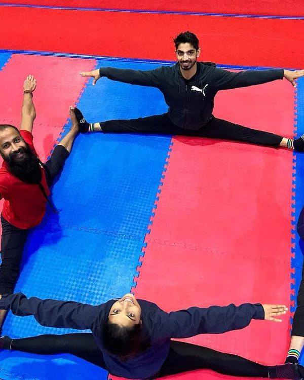 Our students work together on their flexibility. This creative group formation shows four athletes holding a full middle split, a testament to their dedication and our training methods.