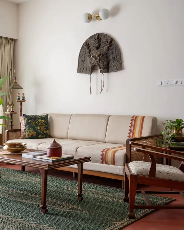 The living area of the Layam residence, featuring our Gubbi Sofa with a custom hand-block printed pattern reminiscent of the 'kara' border in Kerala textiles. The space is completed with the Kathakali-inspired Layam center table.