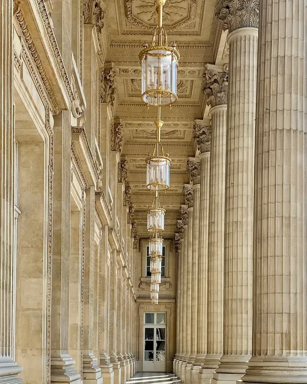 Walking through Paris, I am always captivated by the perfect symmetry and grandeur of its architecture. This colonnade, with its repeating columns and magnificent chandeliers, is a beautiful example of timeless design. These are the moments that fuel my creativity long after I've returned home.
