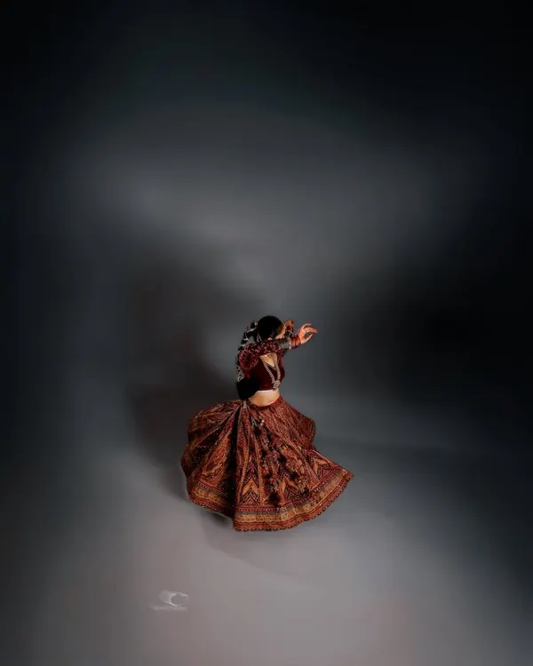 A portrait of movement and solitude. The swirl of the lehenga is captured in a dance of shadow and light, creating an image that is both dynamic and deeply introspective.