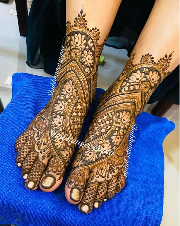 A full-coverage bridal foot design with intricate floral and paisley patterns. The design flows beautifully from the toes up to the ankle, creating an elegant and complete bridal look.
