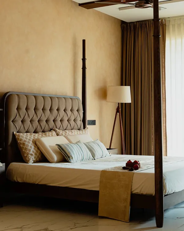 This four-poster bed is a masterpiece of classic design, crafted from solid wood to create a commanding presence. Paired with a tufted headboard and set against a warm, textured wall, it turns the bedroom into a luxurious and stately retreat.
