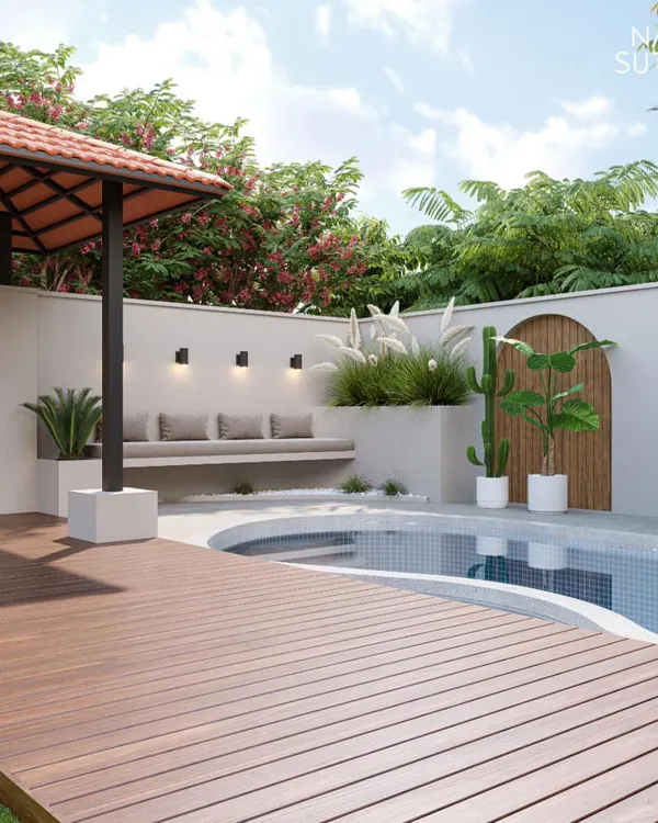 This poolside design features a raised wooden deck leading to a curved pool, complemented by a built-in seating area and a tiled-roof gazebo. We used a mix of pampas grass and cacti to add texture and create a modern, slightly rustic feel.