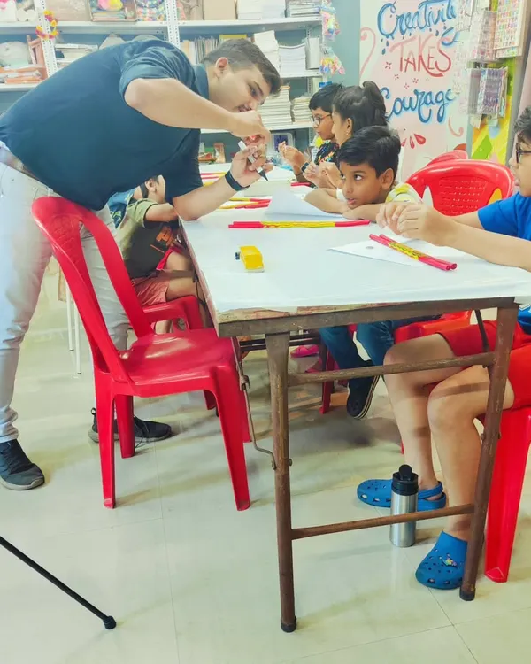 Our Robotics 101 session in full swing. Here, our instructor is explaining the basics of circuits to an engaged group of young innovators.
