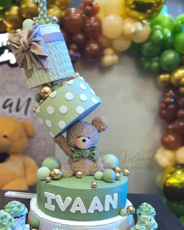 A close-up of our topsy-turvy teddy bear cake, made for Ivaan's first birthday. The design features stacked, angled gift boxes and a sweet, handcrafted teddy bear, all balanced perfectly.