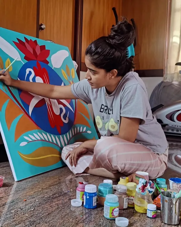This is where the magic happens. A candid shot of me working on the floor, completely absorbed in painting the details of the custom symmetrical crane artwork, surrounded by my paints.