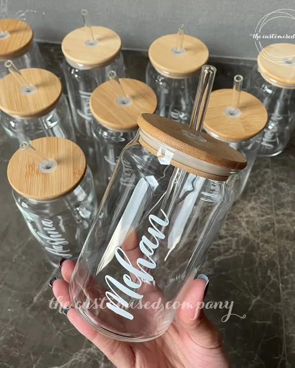 Cheers to staying hydrated! These personalized glass can-style sippers with bamboo lids and glass straws are a stylish and eco-friendly way to enjoy your favorite beverages.