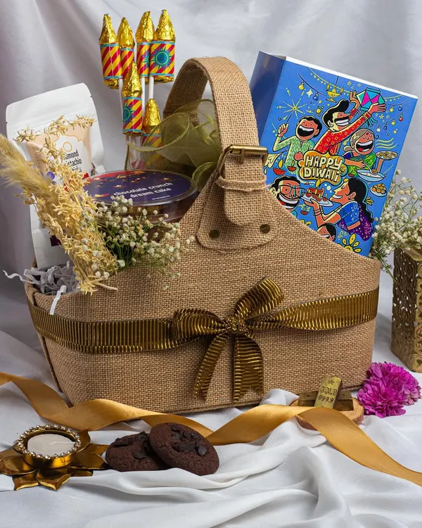 This jute basket hamper captures the essence of a traditional Diwali. It's filled with our signature chocolate chip cookies, a jar of dry fruits, chocolate pataka crackers, and a hand-painted diya, making it a complete and thoughtful gift for your loved ones.