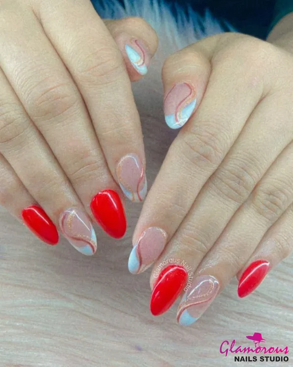 A sophisticated and artistic design. This set combines bold, glossy red nails with accent nails featuring abstract, free-flowing swirls of red and light blue on a nude base.