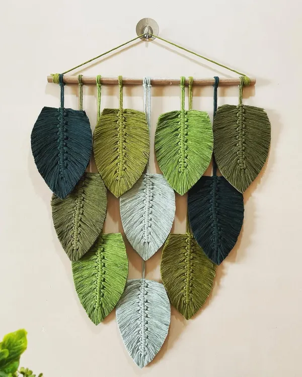 This large, cascading leaf wall hanging is one of my signature pieces. I used various shades of green and grey cotton cord to create a design that feels lush and natural, like foliage on a wall.