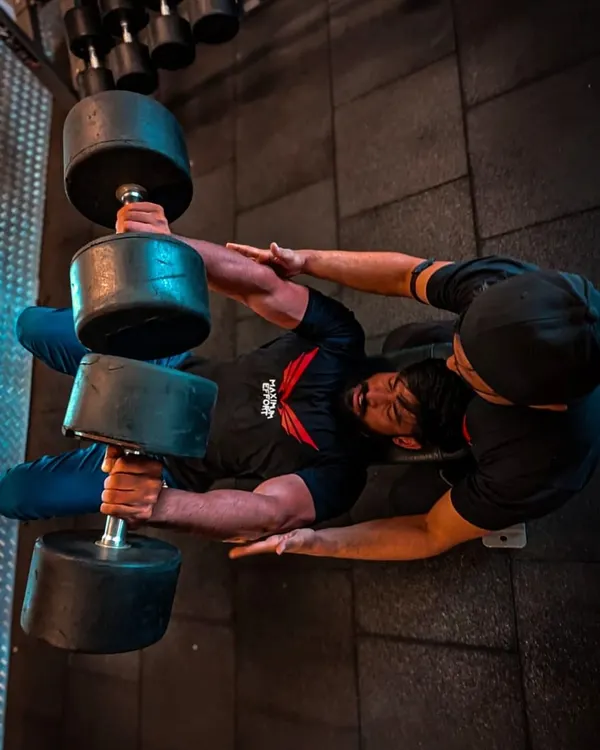 An overhead shot of a heavy dumbbell chest press, a fundamental exercise for building chest mass and strength. My spotter ensures I can push to failure safely.