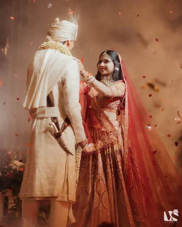The Jaimala ceremony is a moment of beautiful anticipation. As Tanishqa places the garland, surrounded by a shower of petals, we capture the beginning of their union with a sense of cinematic grandeur.