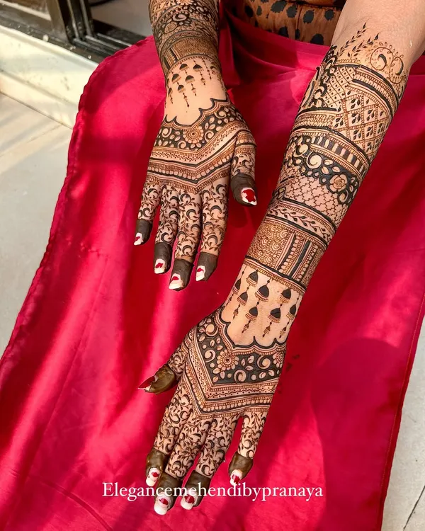 A stunning backhand design for an engagement, with a V-shaped pattern that elongates the hands and intricate details up the arm.