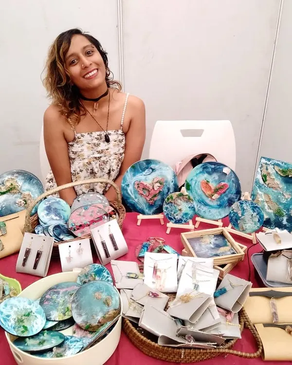 Me at my pop up stall at Maker Mela, surrounded by my handmade resin art. I love interacting with people and seeing their faces when they realize each piece is handcrafted, often from repurposed materials.