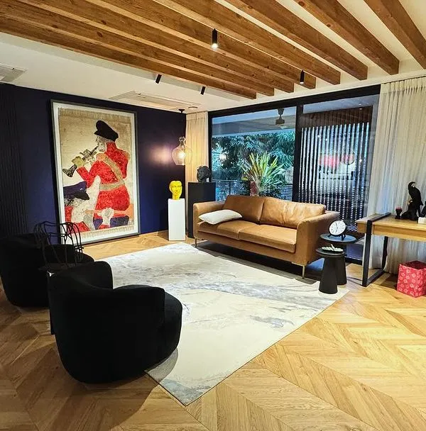 This open-plan study is designed to be warm and cozy, sitting at the heart of the home. We used herringbone wood flooring and exposed ceiling beams to add rustic warmth, while the deep navy accent wall and vibrant artwork create a bold focal point. It’s a space that feels both connected to the rest of the house and like a private retreat.