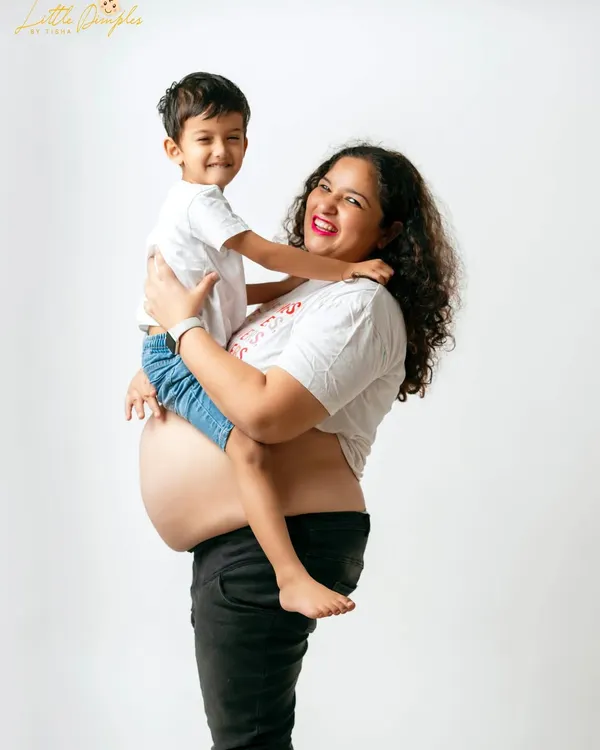 A joyful moment between a mom and her son. Including older siblings in the maternity shoot is a wonderful way to make them feel special and excited.