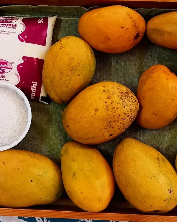 The simple, fresh ingredients for our mango milkshake activity. We use seasonal fruits like these delicious mangoes, along with milk and a little sugar, to create a healthy and refreshing treat.