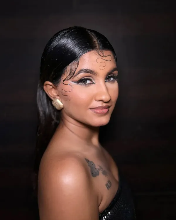 This editorial look combines a wet-look hairstyle with a bold, abstract graphic eyeliner. The skin is kept fresh and glowing to balance the strong eye, creating a modern and high-fashion statement.