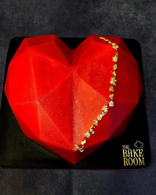 This geometric heart piñata cake is a modern and exciting way to celebrate your love. It has a hard chocolate shell that you can break open to reveal a surprise of cakes, chocolates, or other treats inside.