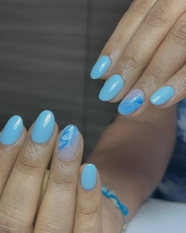 A beautiful sky blue set with a delicate marble accent nail. It's giving ocean vibes.