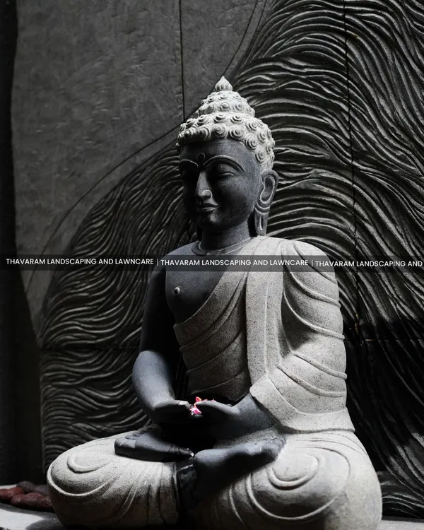 A close-up of a meditative Buddha statue, carved from stone with incredible detail. The textured, wave-like background adds to the sense of calm and focus.