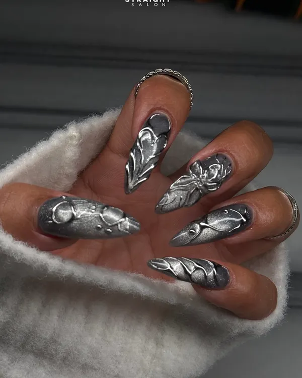 This is the level of artistry I bring to the table. Intricate, hand-sculpted silver chrome art on sharp stiletto extensions creates a look that's pure metal couture and guaranteed to make a statement.