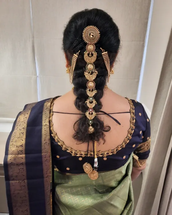 A perfect example of a traditional Muhurtham hairstyle. This long braid is decorated with a full set of golden, temple-style jada billalu, creating a grand and royal look for the bride.