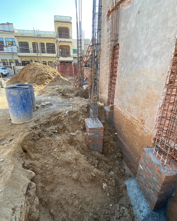 The start of a new builder floor project in Delhi. This image shows the excavation and the placement of rebar for the foundation columns, the critical first step.