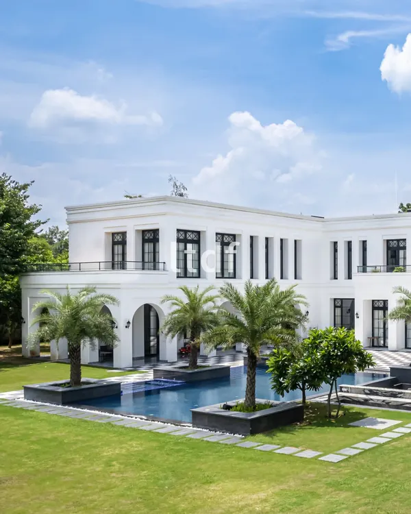 This heritage-inspired farmhouse is a study in timeless grace, where classical proportions meet the comforts of modern living. The pristine white facade and tranquil pool create a dialogue between architectural grandeur and serene landscape design.