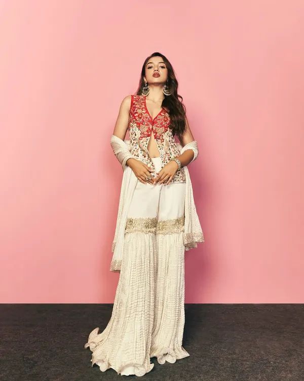 A full-length shot of this beautiful ethnic wear for a Myntra lookbook. The styling focuses on creating a powerful silhouette with the sharara pants and embroidered jacket, perfect for their festive collection campaign.