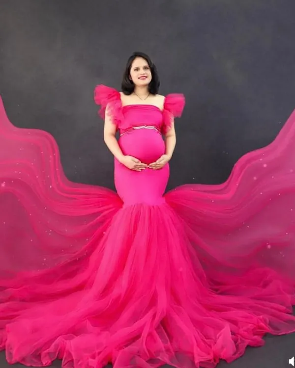 Make a bold statement with this hot pink mermaid gown featuring a dramatic, sparkling train. This studio shot shows how the dress creates an incredible silhouette, perfect for a high-impact glamour portrait.