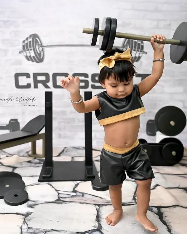 Future weightlifting champion! This little girl shows off her strength in our super fun and unique CrossFit gym setup. These themed shoots are a great way to showcase your baby's energetic personality.
