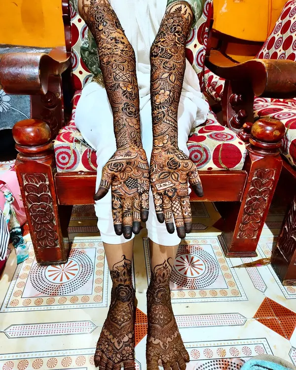 A full view of a complete bridal henna set. The designs on the hands and feet are coordinated to create a harmonious and traditional look, perfect for the wedding ceremony.