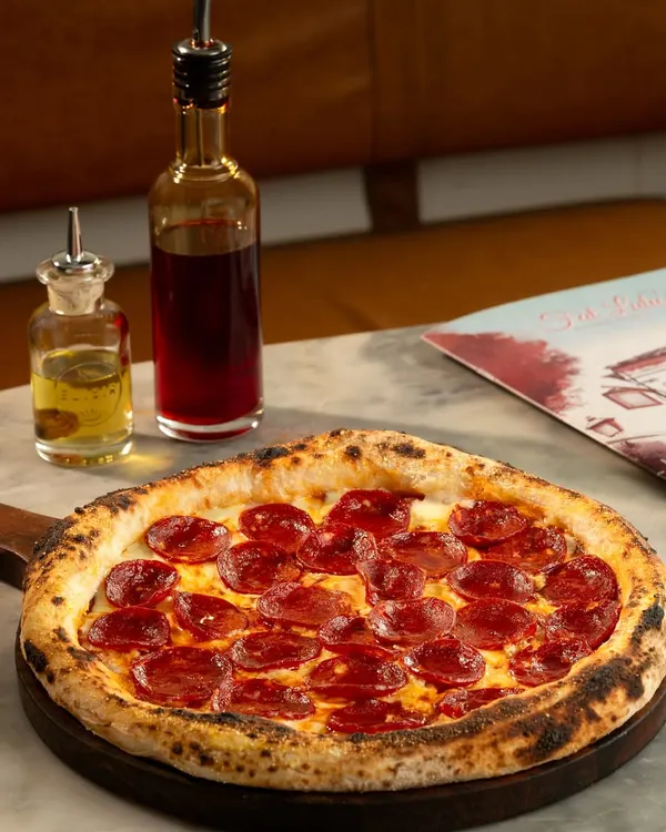 This is what I'm all about. A perfect, wood-fired pepperoni pizza with a blistered, chewy crust, just waiting to be devoured. Drizzle some of my chili oil on it if you dare.