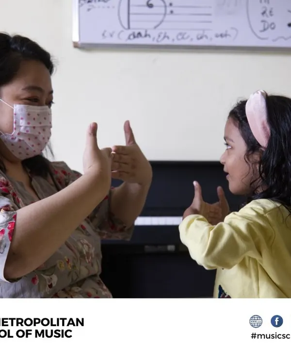 An instructor and a young student share a moment of connection during a music lesson. We create a fun, safe, and educative environment for children, with lessons available on weekends.