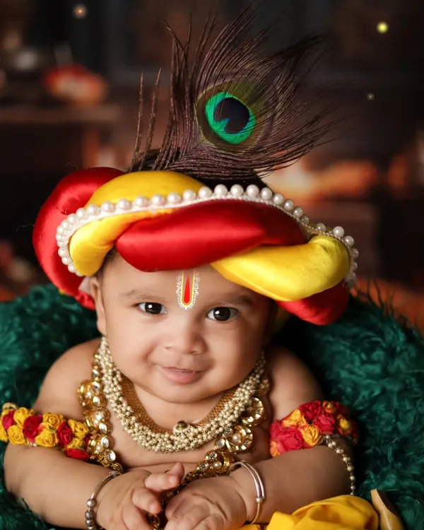 A close-up of a smiling baby Krishna. The peacock feather in his mukut and the pearl necklaces complete this divine look. It’s a joy to create these special Janmashtami portraits.