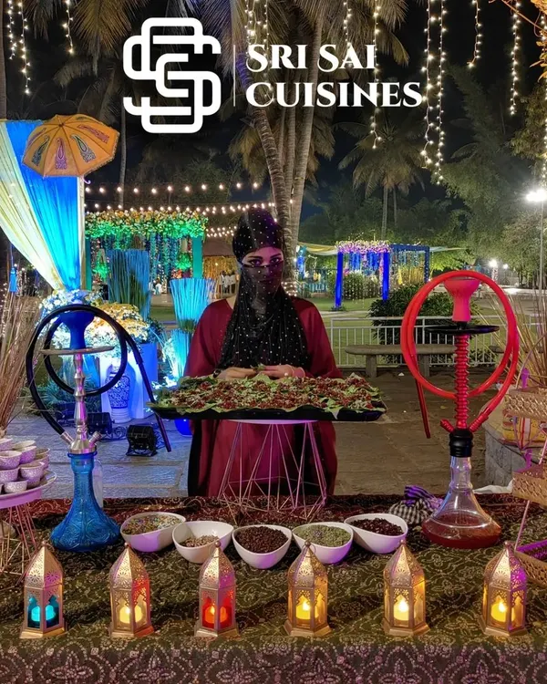 Create an unforgettable experience with our fully decorated Arabian Paan Station. This wide view shows the complete setup, including a professionally dressed hostess, intricate lanterns, and hookahs for ambiance, making it a major attraction at any wedding or sangeet.