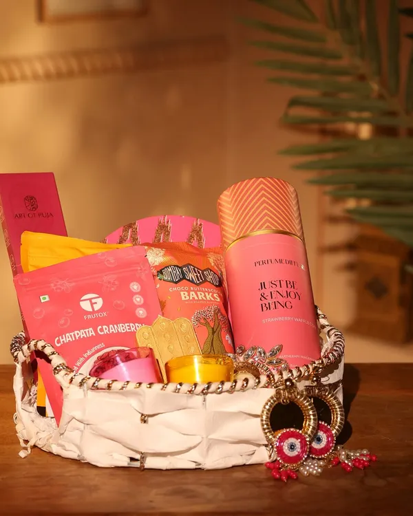 This vibrant pink-themed hamper is part of my Diwali collection, perfect for corporate or personal gifting. It includes gourmet snacks like Chatpata Cranberry, chocolate barks, a scented candle, and stylish evil-eye earrings.