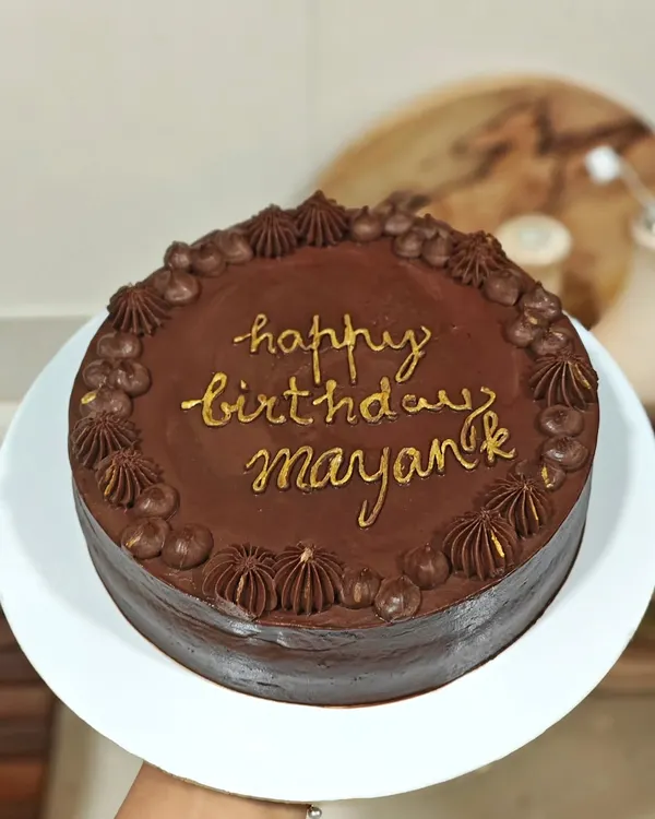 The finished Belgian chocolate and raspberry cake, personalized with a "Happy Birthday" message in gold. A classic flavor combination that's always a crowd-pleaser.