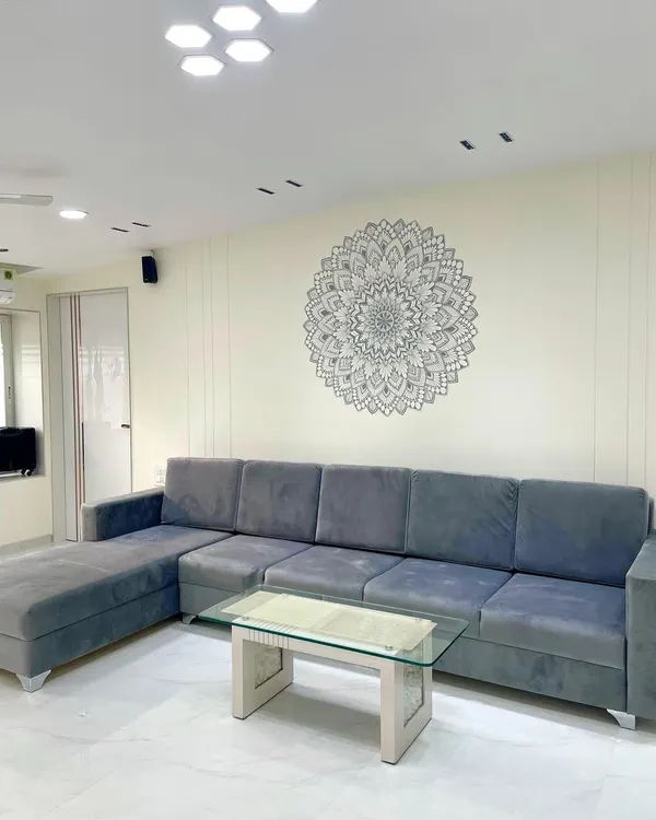 A finished mandala mural creating a serene focal point in a client's living space. The grey and white design adds intricate detail without overwhelming the room's clean aesthetic.