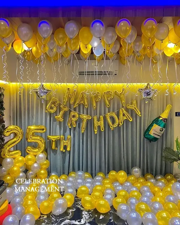 A room bursting with celebration for a 25th birthday! I used a cheerful yellow and silver color scheme, with balloons on the ceiling and floor, plus large foil numbers and a champagne bottle balloon for extra fun.