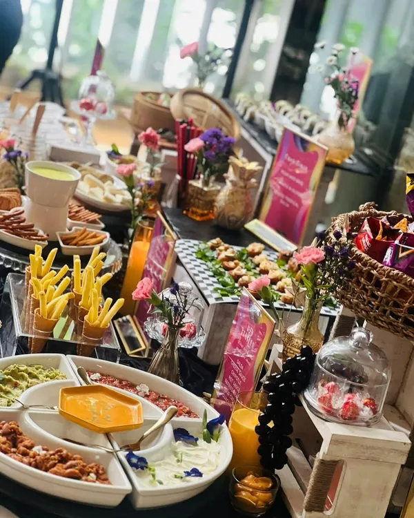 A beautiful summer afternoon table setting featuring a variety of our favorite snacks. This spread includes a dip platter, crispy fries, fresh juices, and other gourmet bites perfect for a relaxed get-together with friends and family.