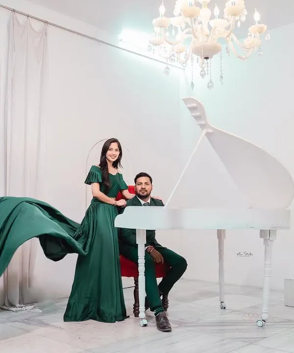 An elegant and dramatic studio shot featuring a grand piano and a beautiful flowing dress. This setup is perfect for couples who want a touch of high-fashion glamour.