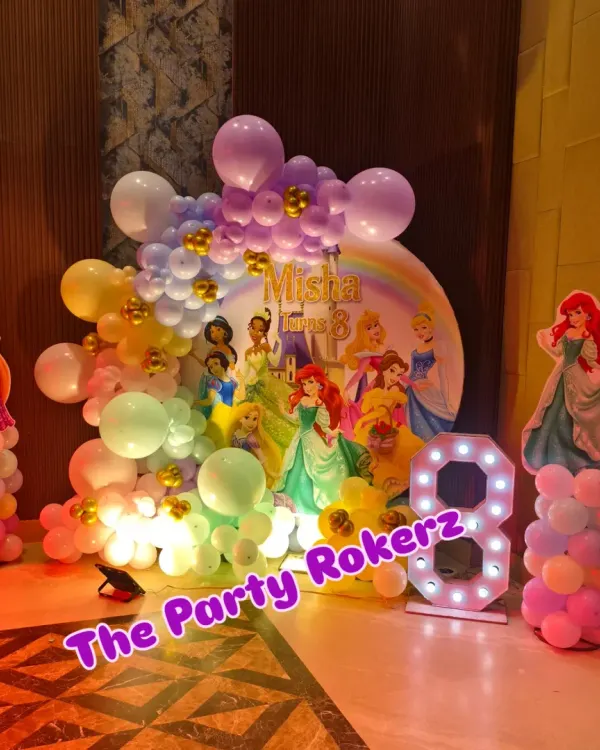 A magical Disney Princess-themed 8th birthday. The main backdrop features a rainbow and multiple princesses, framed by a pastel balloon arrangement and character cutouts.