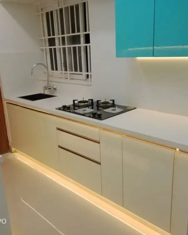 A look at a modern kitchen layout we completed, showcasing a clean and efficient workspace. This design features dual-tone cabinetry, a durable white countertop, and integrated floor and under-cabinet lighting that makes the space feel bright and spacious.